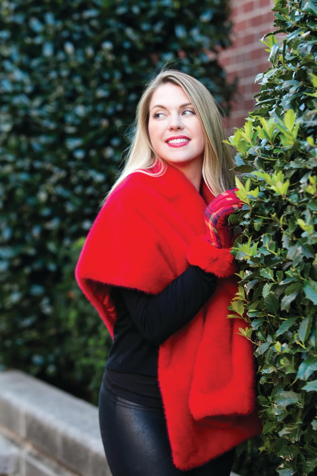 A photo of a woman outside wearing a red elegant shawl.